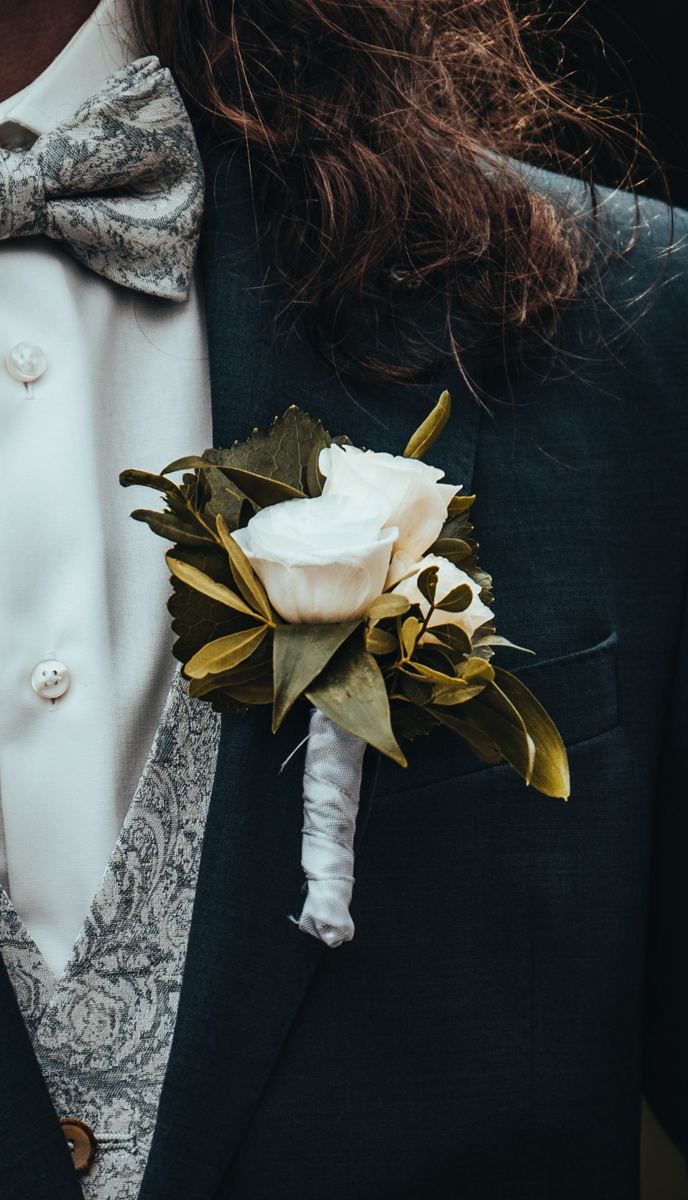 Anstecker mit weißen Rosen am Sakko des Bräutigams